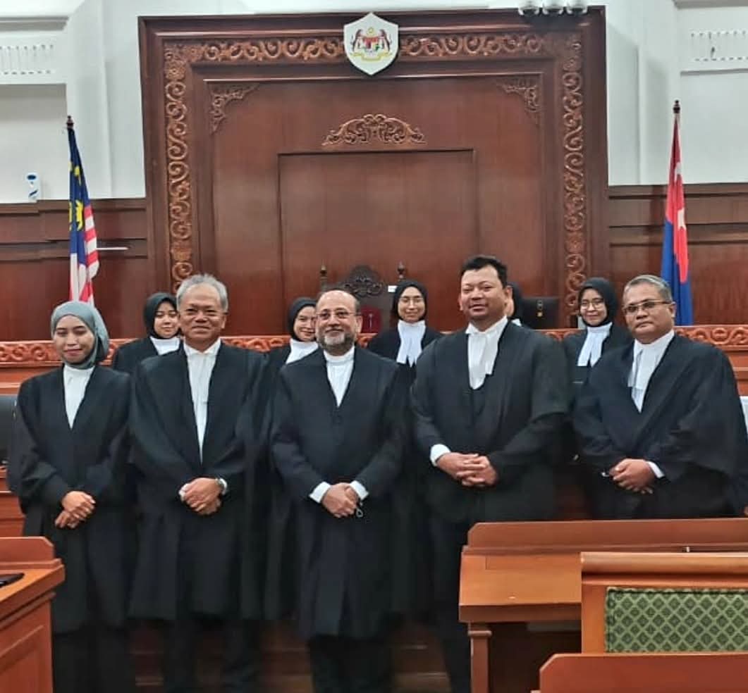 Advocates of the firm in court robes and bands assembled in a Malaysian courtroom.