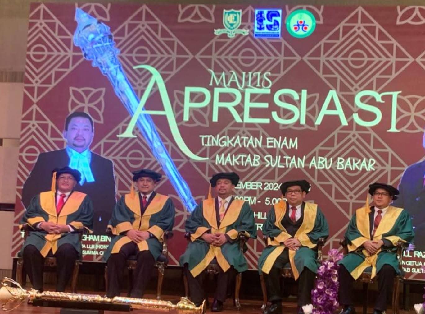On stage in academic robes at the Majlis Apresiasi Tingkatan Enam, Maktab Sultan Abu Bakar.
