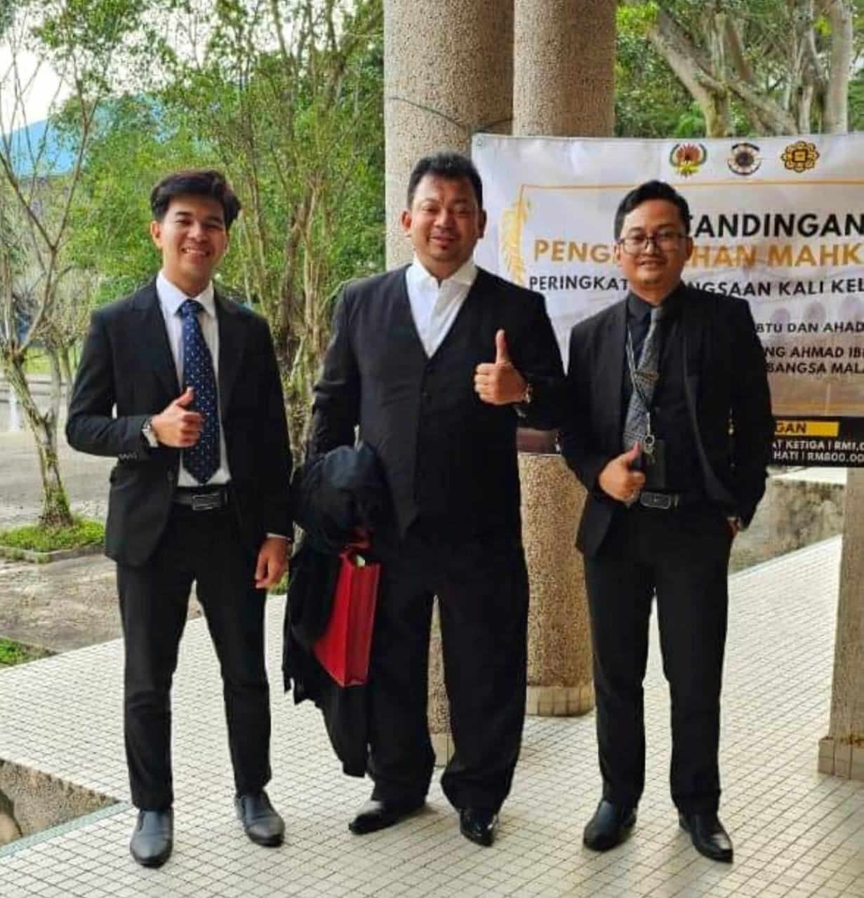 In court dress with two colleagues outside a national-level mooting competition at the Ahmad Ibrahim Kulliyyah of Laws.