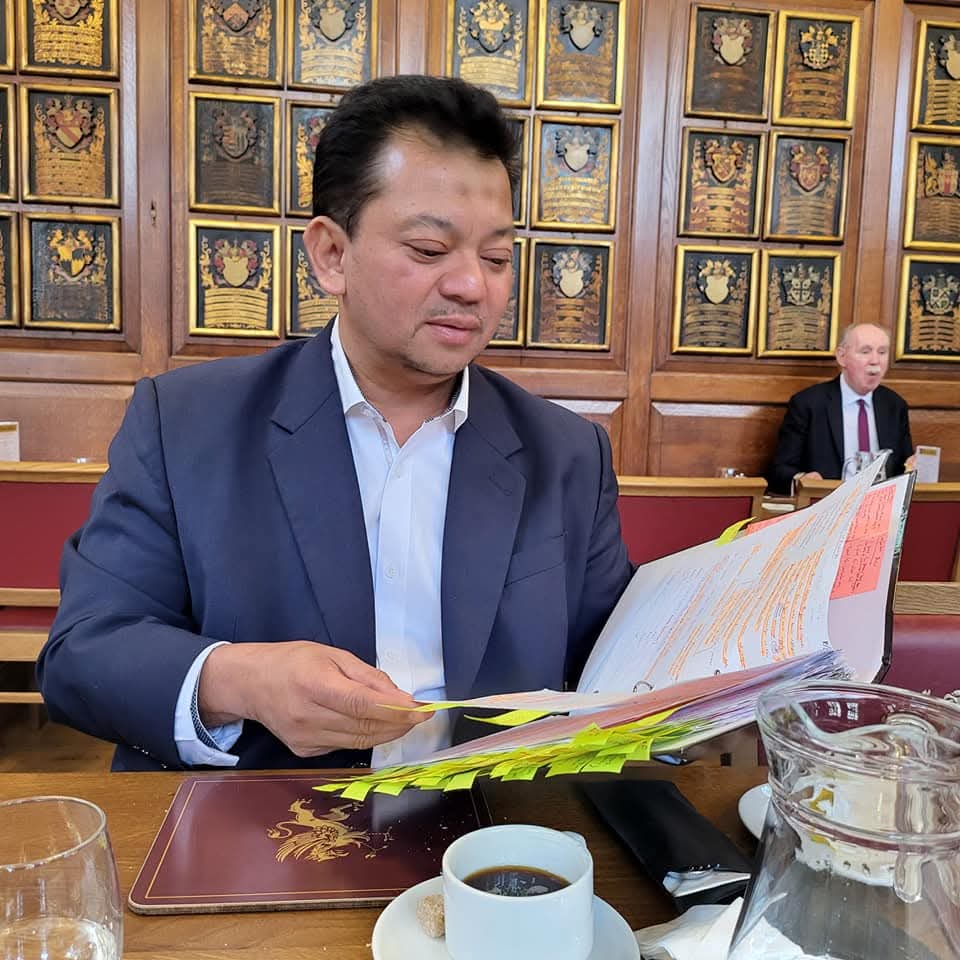 Reading a heavily annotated brief over coffee in the armorial-panelled hall at Gray's Inn, London.